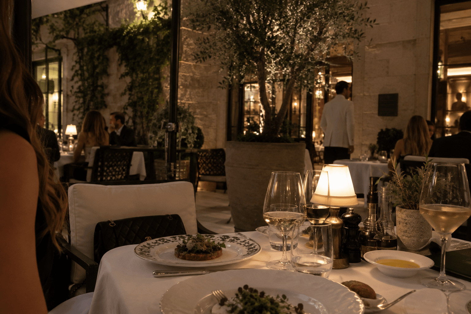 Evening dinner in a stone courtyard restaurant under an olive tree